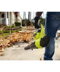 Heavy Duty Cordless Leaf Blower With Jet Fan Tech And Forty Volt Setup Sending Out One Fifty Five MPH Winds, holding in a yard.