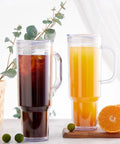 Two 40 Oz Clear Double Wall Acrylic Tumblers With Handle And Straw Lid, one with iced coffee, the other with juice.