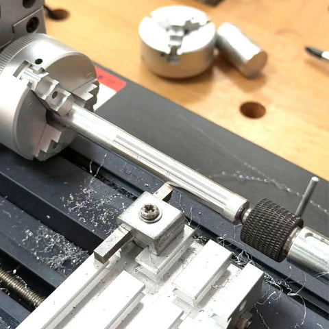 60W Mini Bench Electric Lathe Machine 12000 RPM All Metal Woodworking Tool in action with metal workpiece and shavings.