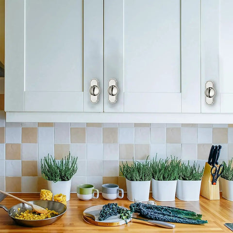 Five Pack Heavy Duty Polished Nickel Cabinet Knobs And Backplates on white cabinet doors in a breezy kitchen setting.