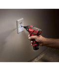 Person using 12 Volt Cordless Hex Screwdriver Kit With Two 1.5Ah Batteries, Charger, And Tool Bag on wall socket at home.