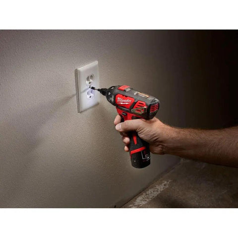 Person using 12 Volt Cordless Hex Screwdriver Kit With Two 1.5Ah Batteries, Charger, And Tool Bag on wall socket at home.