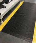 Heavy Duty Anti Fatigue Mat 3 Ft By 6 Ft Diamond Plate Ergonomic Standing Floor Mat in workshop setting with yellow edges
