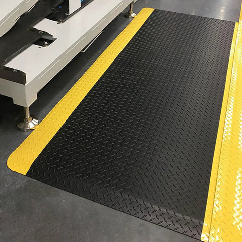 Heavy Duty Anti Fatigue Floor Mat 2 By 7 Feet Extra Thick Fifteen Sixteenths Inch Diamond Plate Standing Pad for Kitchen Workshop and Garage Relieves Leg and Back Pain Anti Static Durable Rubber Mat placed on floor with yellow border showing diamond pattern
