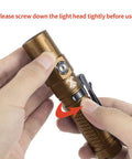 Person holding Beast Mode Bright 2403 Lumen USB C Rechargeable Flashlight With CREE XHP 35.2 LED Desert Tan, screwing light head.