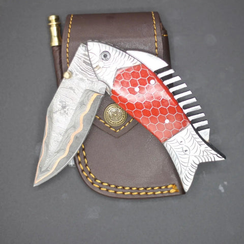 Damascus Steel Folding Knife With Ladder Pattern Blade And Copper Fish Style Handle displayed with leather sheath.