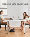 Woman using adjustable ergonomic desk footrest with massage for improved posture and leg comfort in office setting.