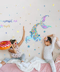 Two girls playing with pillows in a room with Homie Mermaid Wall Decals For Girls Nursery Room Decor And Kids Bedroom Decoration Tail Stickers Baby Girl Purple Tail Wall Decor Eco Friendly Safe Non Toxic Peel And Stick Removable Wall Art on wall.