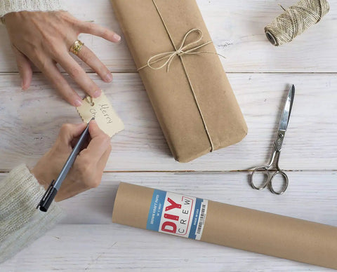 Person wrapping with Straight Up Premium Brown Kraft Paper Roll Hella Thick For Rustic Gift Wrapping And Diy Crafts.