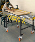 Heavy Duty Expandable Conveyor Roller With 1250 Lbs Hauling Capacity And Smooth Glide Skate Wheels Built For Fast Warehouse Workflows And Zero Sweat Tool Transport in a workshop setting with a worker.