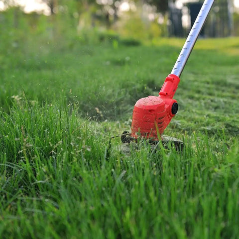 Red electric string trimmer in a garden using 7 Piece Carbide Tipped Grass Trimmer Blades Set For 6 Inch 40 Teeth Replacement Weed Wacker Blades For Electric String Trimmers Metal Cutter Heads For Thick Weeds And Small Branches cutting grass.