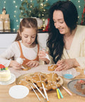 A mother and daughter decorating cookies using the Level Up Your Sweet Baking Game With This Solid Acrylic Cookie Decorating Turntable Kit.