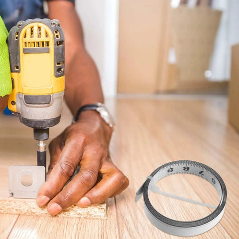 No Fuss Self Adhesive One Meter Steel Metric Track Ruler Tape next to a worker using a drill on wood for precise measurements.