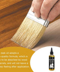 Premium 100ml Teak Oil For Wood Furniture And Hardwood Floor Restoration being brushed onto wood surface for an even finish.