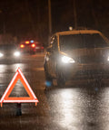 DOT Approved Vehicle Safety Triangles Three Pack With Carry Case Emergency Reflective Warning Signs on wet road with car in background.