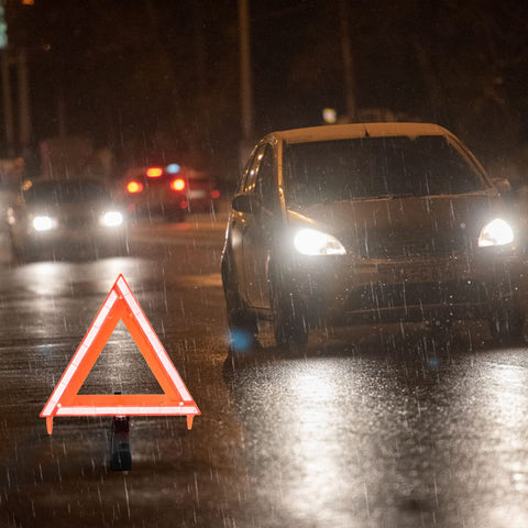 DOT Approved Vehicle Safety Triangles Three Pack With Carry Case Emergency Reflective Warning Signs on wet road with car in background.