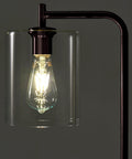 Close-up of Tall Edison Bulb Floor Lamp With Glass Shade In Bronze Finish, illuminated bulb detail, industrial vintage style