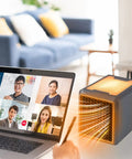 Kick Chilly To The Curb With This Compact Ceramic Space Heater, Plug Straight In At Any Wall Outlet To Blast Serious Turbo Warmth For Cozy Rooms And Offices, Keeps You Snug During Freezing Weather near a laptop during a video call.