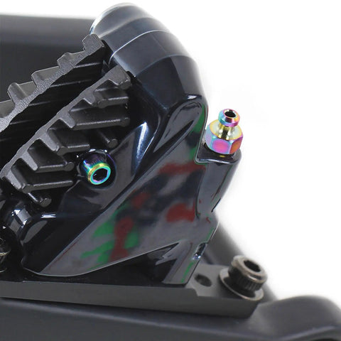Close-up of Badass Titanium Alloy Brake Bleeder Screw Set With Dust Caps for Motorcycles on a brake caliper.