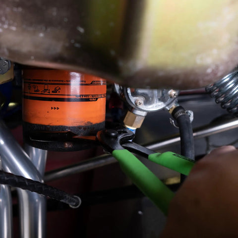 Beefy Oil Filter Pliers For Tight Spots in use, adjustable jaw grips a 2.5 to 4.625 inch filter, slip joint design, cushioned handles visible