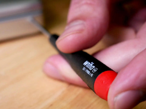 Close-up of hand using PicoFinish Mini Precision Screwdriver Set, 7-Piece Slotted And Phillips With Rotating Caps for repairs.