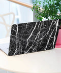 Laptop covered in black marble countertop contact paper peel and stick vinyl wrap waterproof self adhesive, table background.