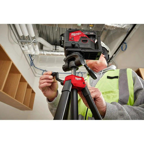 Worker adjusts Heavy Duty 72 Inch Laser Tripod With Removable Mounting Plate And One Quarter Inch Twenty Thread Attachment indoors
