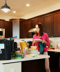 Woman tidying a kitchen under Sweet 4 Pack Ultra Thin 6 Inch LED Recessed Ceiling Lights With 3 Color Temperatures 3000K 4000K 5000K Dimmable 12W Equivalent To 110W Canless IC Rated Downlights With Junction Box ETL Energy Star lighting.