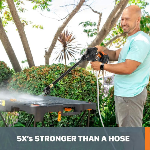 Man using Hydroshot 320 PSI Portable Power Cleaner With 20V Power Share System to clean outdoor table, battery-powered.