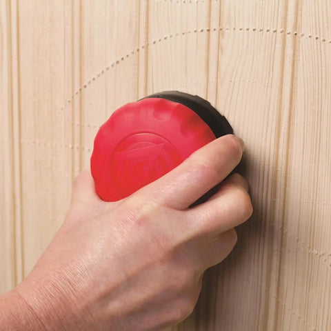 Hand using PaperTiger Triple Head Wallpaper Removal Scoring Tool on wood wallpaper for easy stripping and adhesive penetration.