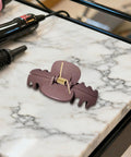 8 Pack Hair Clip Spring Replacement with strong clamping steel jaw clip on marble counter next to hair tools