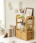 Bamboo Bathroom Countertop Organizer With 2 Tier Makeup Storage And 2 Drawers, compact eco-friendly shelf on desk with decor items.