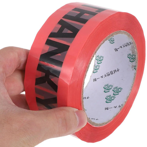 Pink Packing Tape Roll Set For Shipping Boxes, 7 Rolls, 100 Yard Each, Heavy Duty Moisture Resistant Sealing Tape For Moving And Packaging, Built Tough, Easy Tear, Ideal For Boxes Bags And Mailers. Hand holding pink packing tape roll.