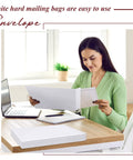 Person using 50 Pack Bulk Large Rigid Mailers 13 x 17.75 Inch Self Seal Cardboard Envelopes at home office desk