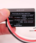 Close-up of Two Pack Outdoor Dusk To Dawn Light Sensor Controllers showing wiring and specifications label for home safety.