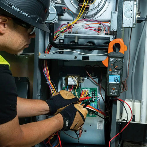 Technician using HVAC Clamp Meter All In One With Auto Ranging TRMS And NCVT Inrush And More For Voltage Current And Temperature.