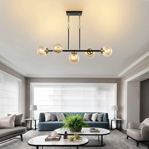 5 Light Modern Sputnik Island Pendant Light Fixture With Amber Glass Globe Shades over living room area with sofa and tables