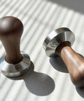 Two 53.35mm Espresso Tamper With Wood Handle And Food Safe Stainless Steel Base Precision Fit For 54mm Espresso Baskets Ideal For Home Baristas Comfortable Grip Italian Made on sunlit surface.