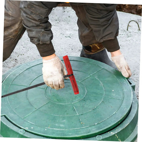 Heavy Duty Multi Function Manhole Cover Lifter With Thick T Shaped Handle For Roller Shutters And Sliding Doors Top Notch No Sweat Pulling Tool Set Pro Grade in use to lift a green drainage cover.