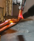 Five 3/8-inch straight copper fittings with sweat joints installed on a copper line near a valve