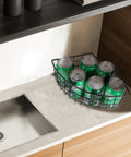 Black metal corner Lazy Susan basket under kitchen cabinet, 9x6.2x4 in, holding cans.