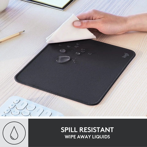 Studio Series Mouse Pad With Anti Slip Rubber Base, Spill Resistant Surface, Easy Gliding, Durable Materials, Portable Desk Mat In Graphite, Fresh Modern Design For Home Office And Gaming, shown repelling water on wooden desk