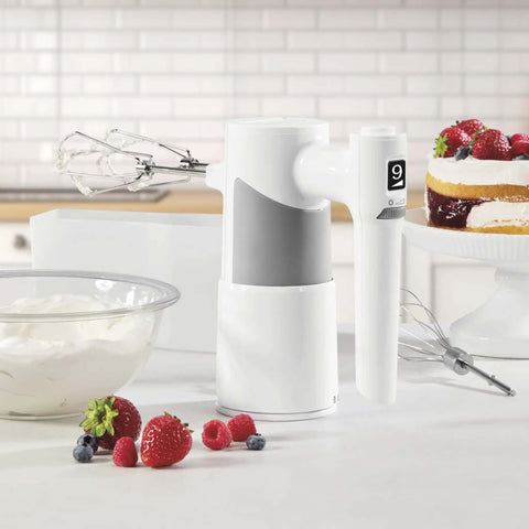 Lightweight Nine Speed Electric Hand Mixer With Grippy Ergonomic Handle And One Touch Digital Controls on kitchen counter with berries.