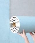 Waterproof Thermal Insulating Wallpaper Roll That Slaps Together Without The Sweat For Bedroom And Living Room Decor Easy Install Blue Peel And Stick Wall Panels Total Flex Upgrade held in hands, showing texture and roll.
