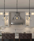 11 Inch Mid Century Modern Pendant Light With Clear Glass Dome Shade And 6 Foot Adjustable Cord For Kitchen Islands, Dining Rooms Or Game Rooms In Blackened Bronze Super Sleek illuminating a kitchen.