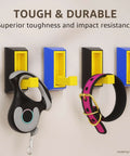 Wall hooks demonstrating superior toughness and impact resistance with a dog leash and collar hung on them.
