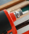 Close-up of 1-1/4x8TPI male spindle adapter on a red woodworking lathe headstock; metal finish with jackscrew