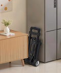 Foldable Hand Truck For Quick Moves 110 Lb Load Capacity Collapsible Luggage Cart With 2 Wheels And Elastic Rope beside cabinet