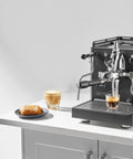 Alto Espresso Machine With Flow Control, Dual Boiler and PID for Precise Temperature in black, on kitchen counter with coffee.