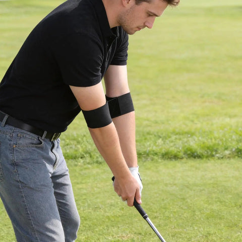 Man using Swing Correcting Arm Band 4 Pack Elastic Golf Swing Trainer For Right And Left Handed Players No Chicken Wing Aid on golf course.